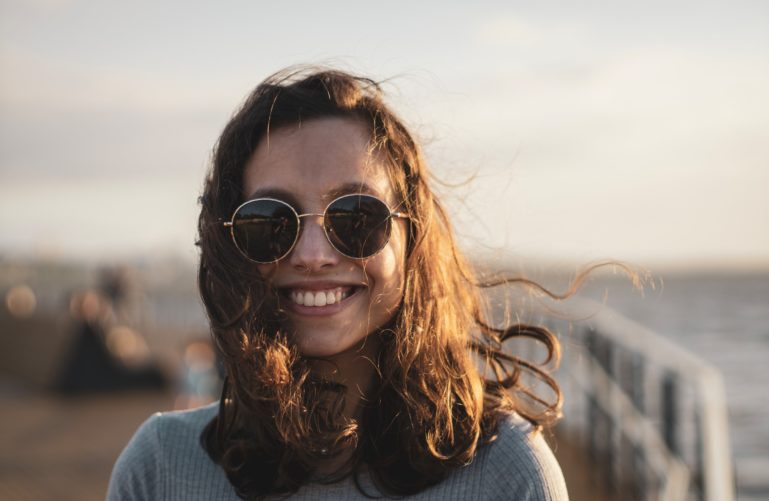 a smiling girl in sunglasses