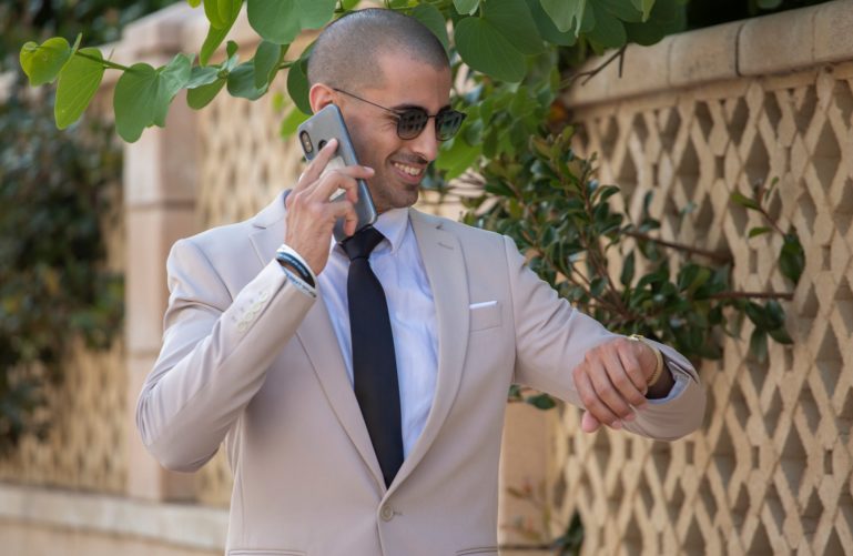 A man in a suit holding phone