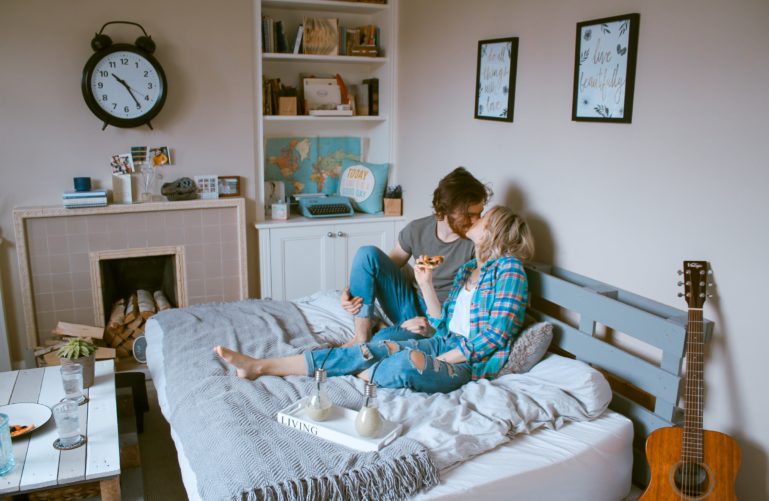 A couple is kissing on a bed